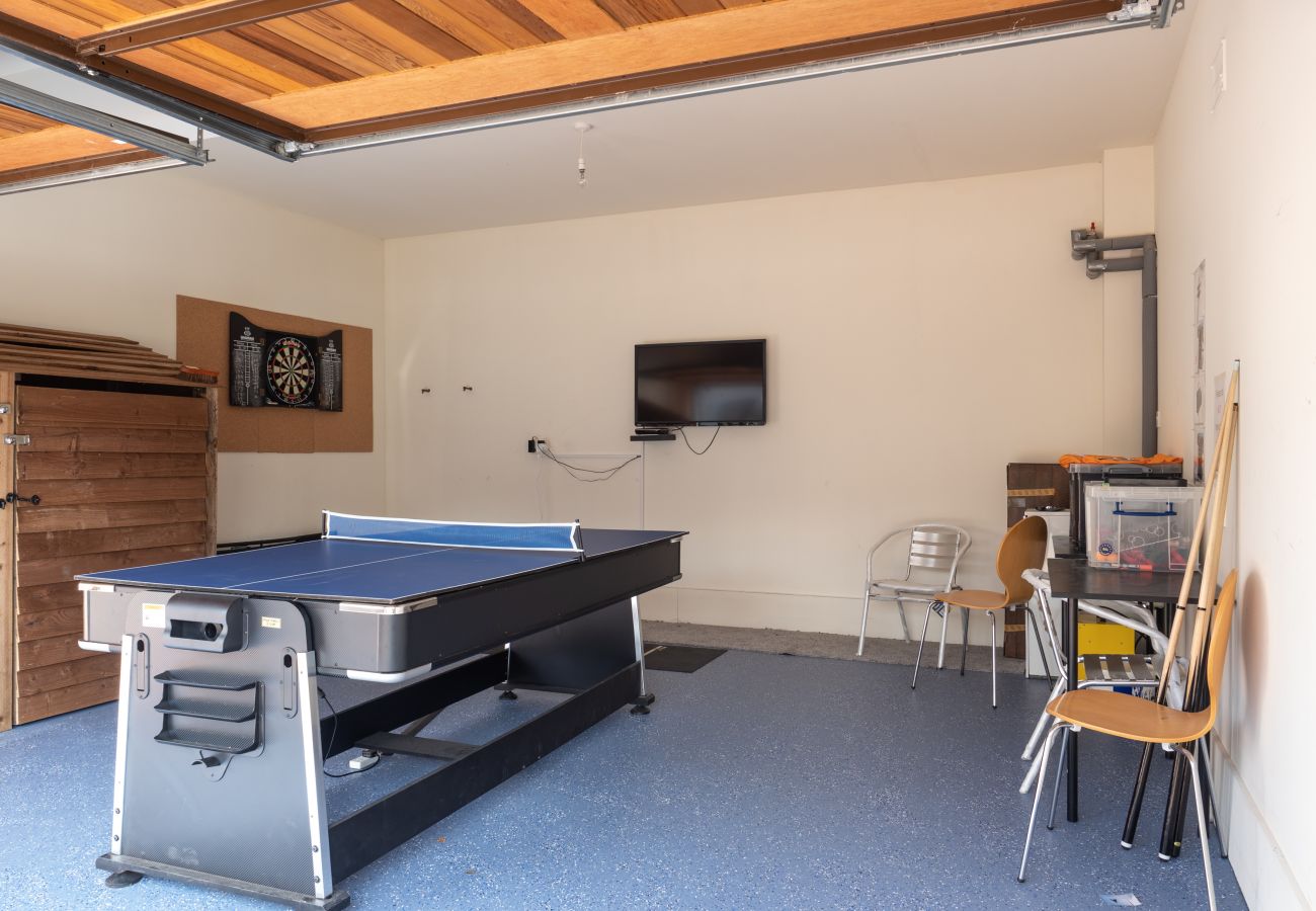Games set up in an Aviemore lodge with multi table games, dart board and tv.