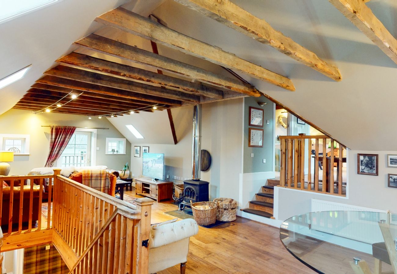 Living room in holiday lodge in converted mill with historic original features and log burner