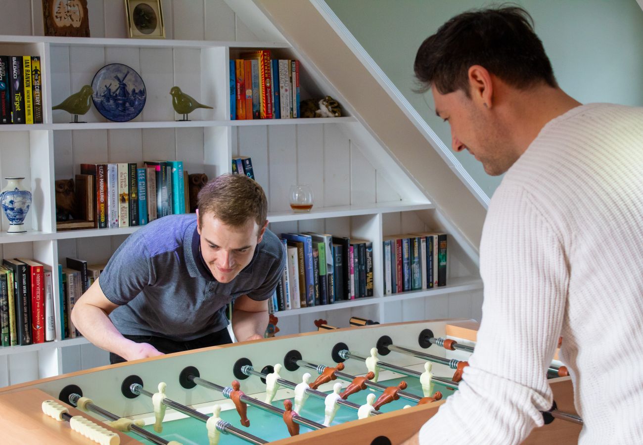 Two friends enjoy a game a of table football at a Scottish holiday lodge.