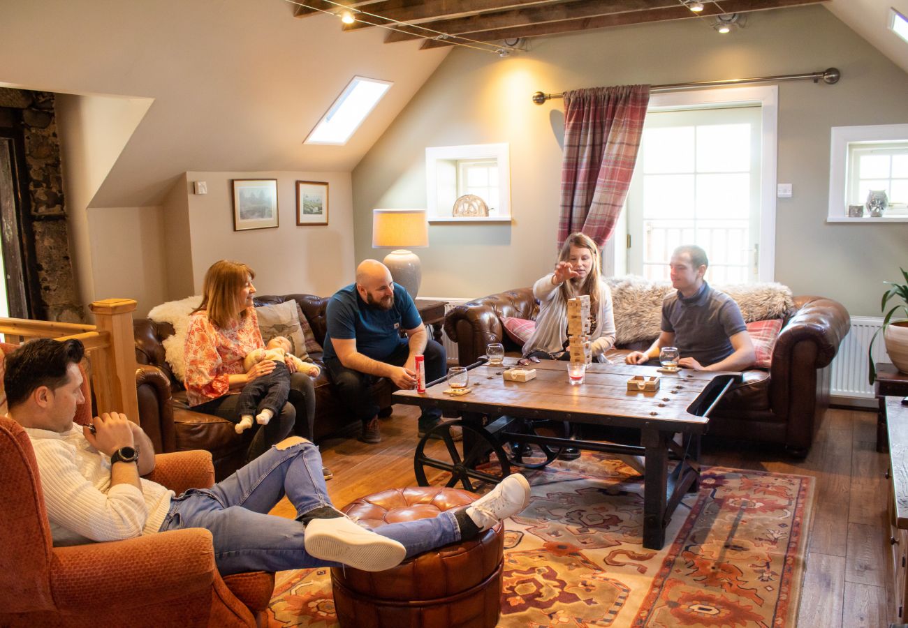 Family enjoying games in the living room at The Maltings, self catering lodge.