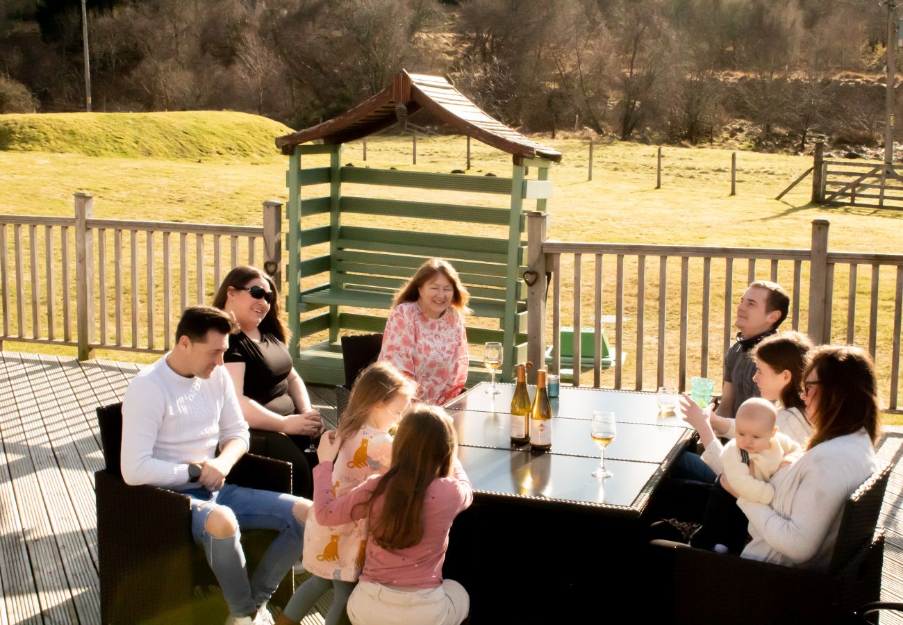 A family enjoys time together on decking outside a holiday lodge