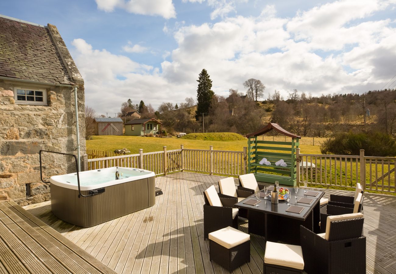 Outside Scottish holiday property with decked area, hot tub, bbq and enclosed garden.