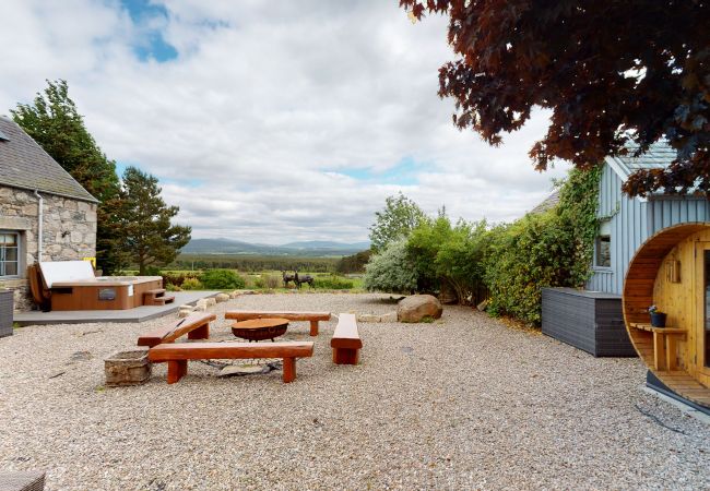 Hot tub, fire pit and sauna outside large holiday lodge in Cairngorms