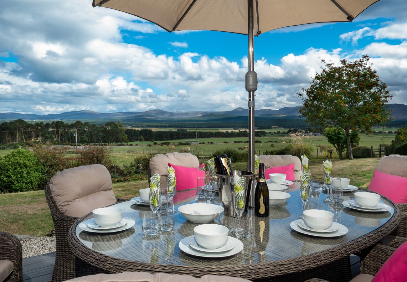 Outdoor dining with view of Cairngorms from a luxury lodge