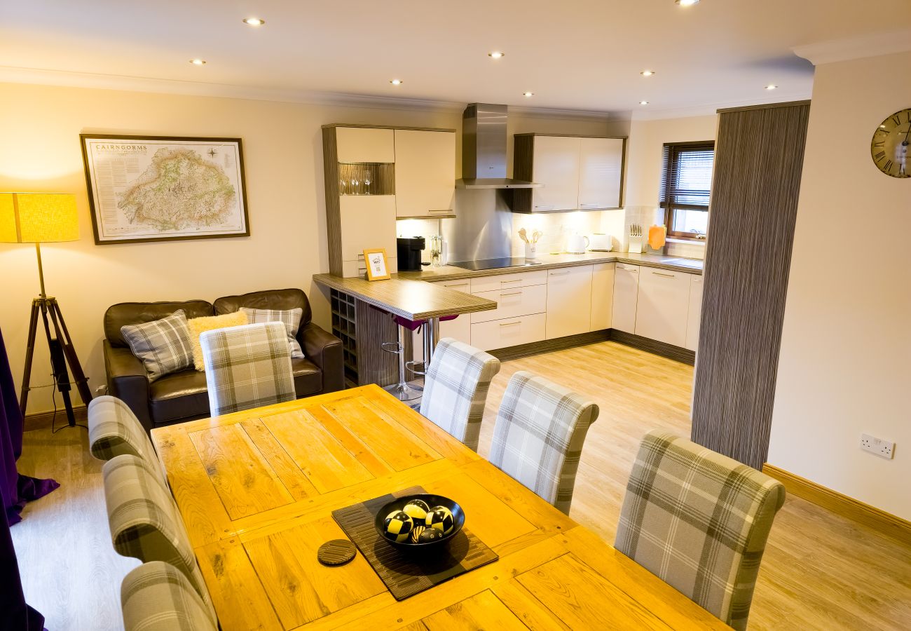 A bright dining area with seating for eight in an Aviemore holiday lodge