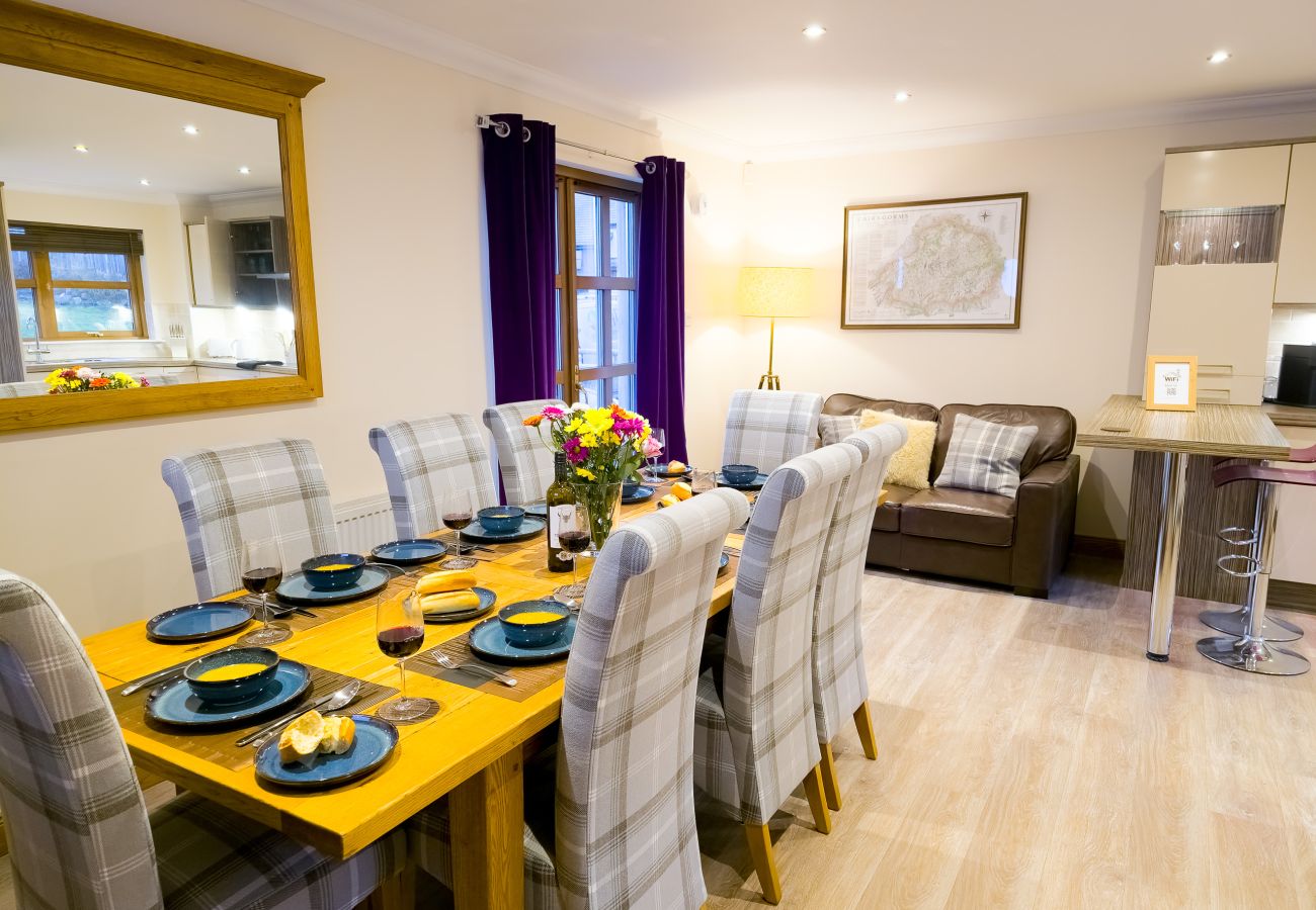 A bright dining area with seating for eight in an Aviemore holiday lodge