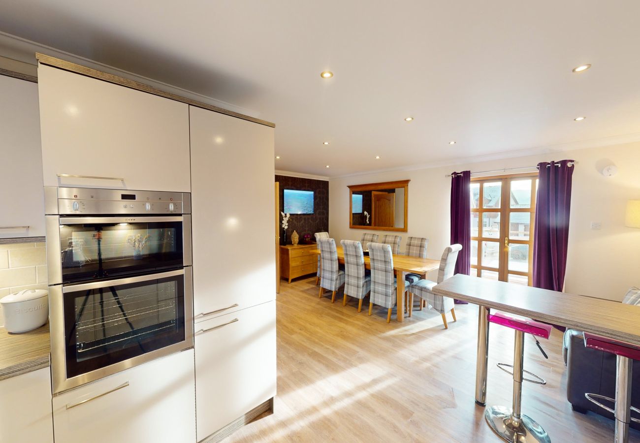   A fully equipped modern kitchen with open plan dining space in an Aviemore lodge