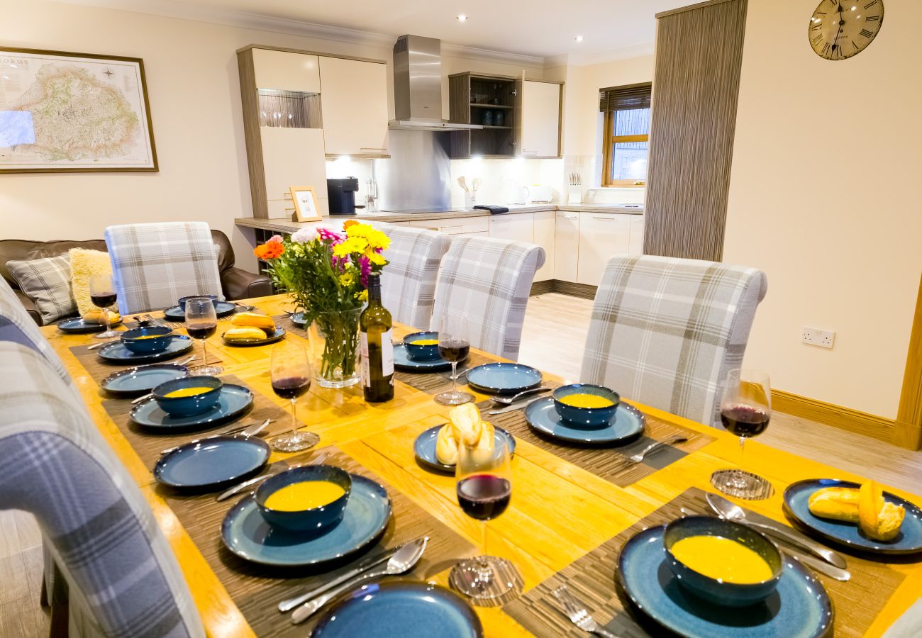 A bright open plan dining area with seating for eight in an Aviemore holiday lodge