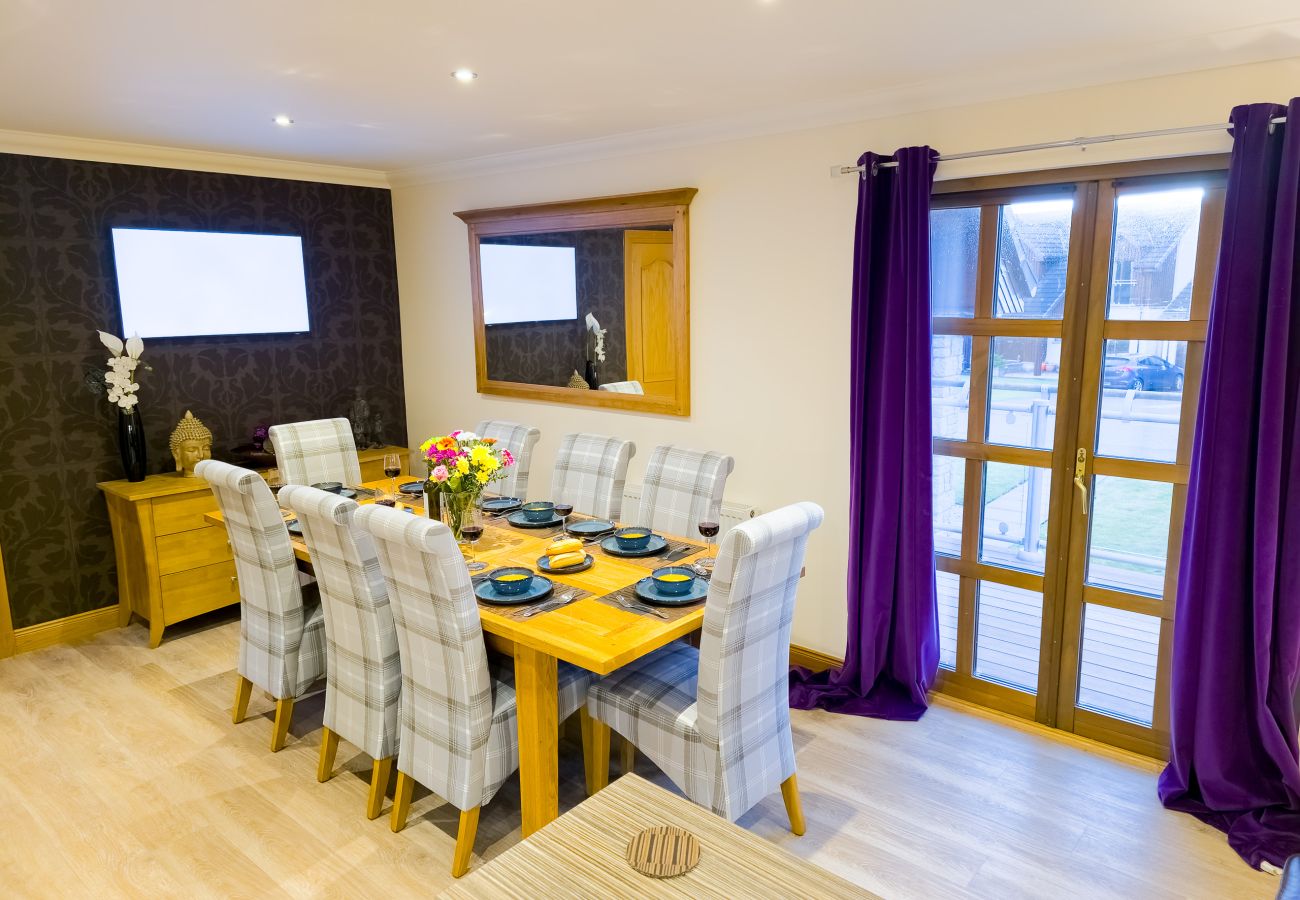 A bright dining area with seating for eight in an Aviemore holiday lodge