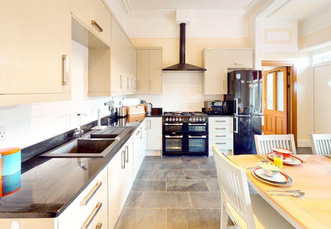 Modern kitchen with a large counter and windows overlooking the Scottish Highlands in a Laggan holiday home