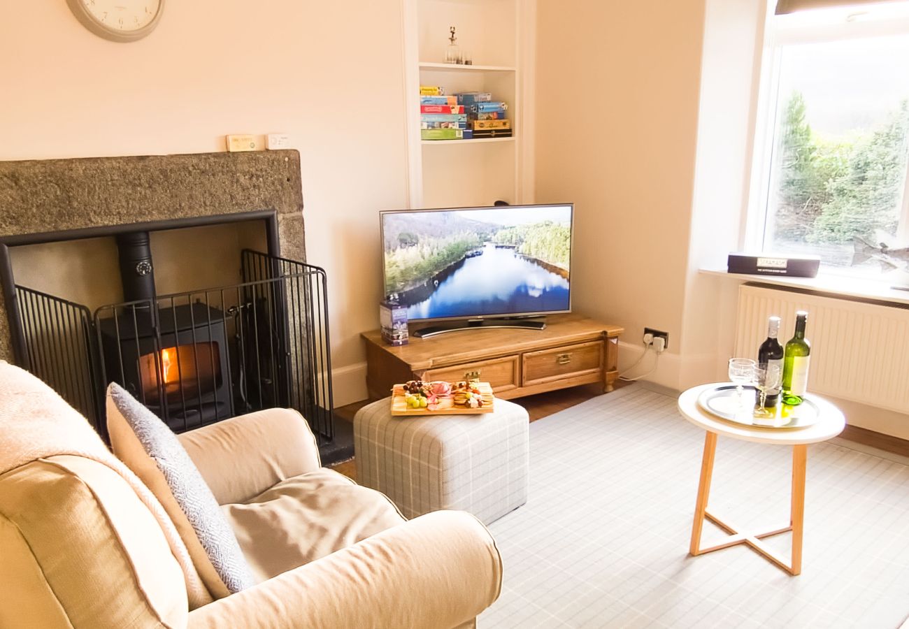 Lounge with a fireplace and warm furnishings in a holiday home in the Scottish Highlands.