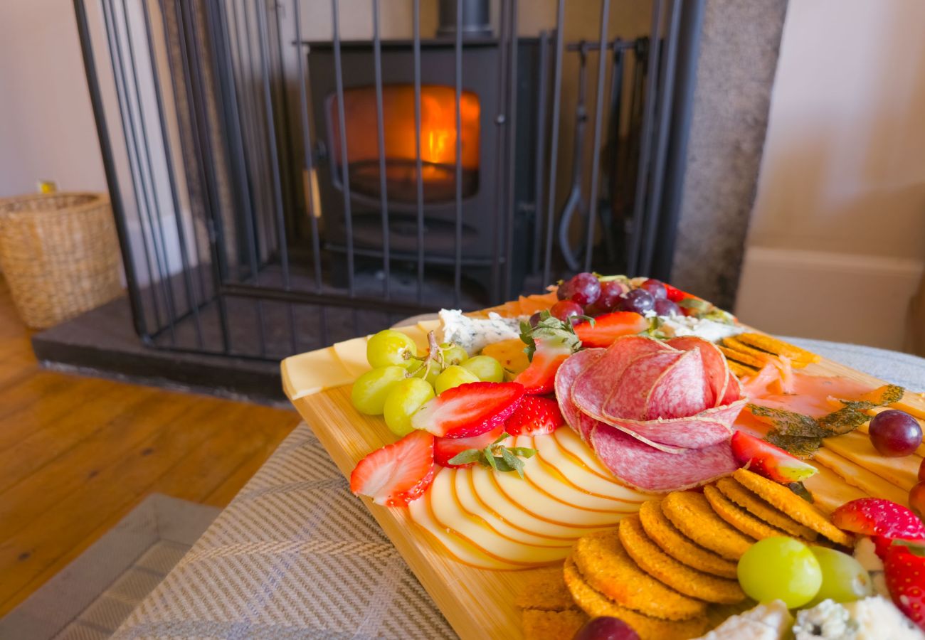 Cheeseboard with assorted cheeses, fruits, and crackers in a cozy holiday home in the Scottish Highlands