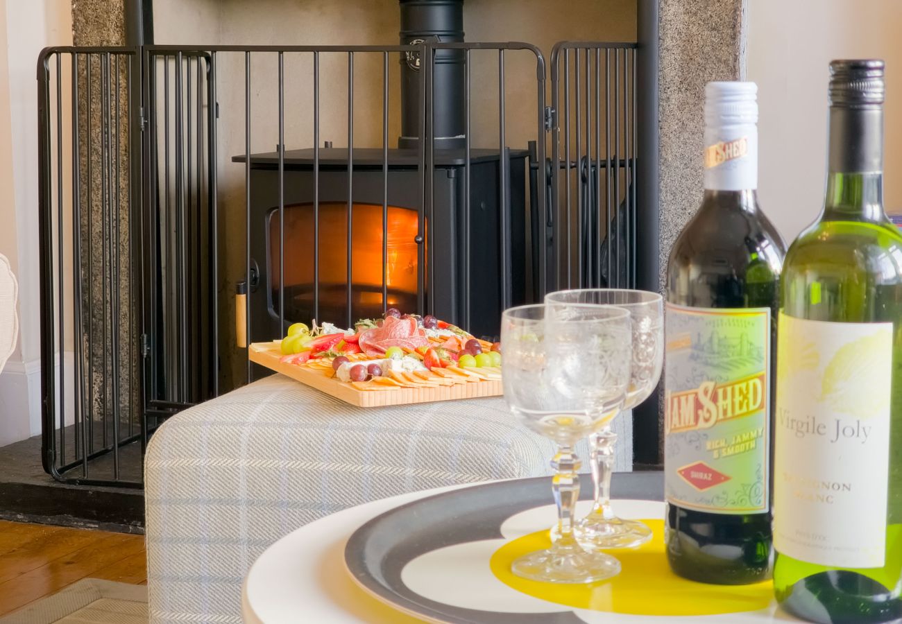 Fireplace with a bottle of wine, creating a warm and inviting atmosphere in a holiday home in the Scottish Highlands