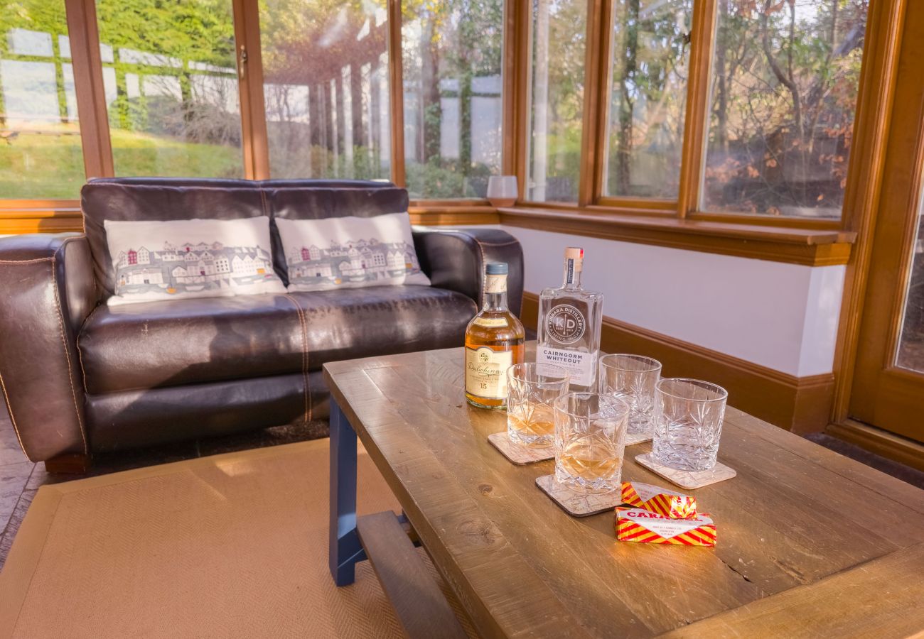 Conservatory with seating and garden views in a Laggan holiday home