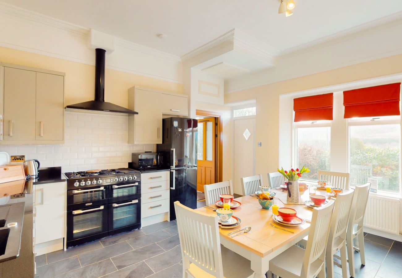 Modern kitchen with a large counter and windows overlooking the Scottish Highlands in a Laggan holiday home