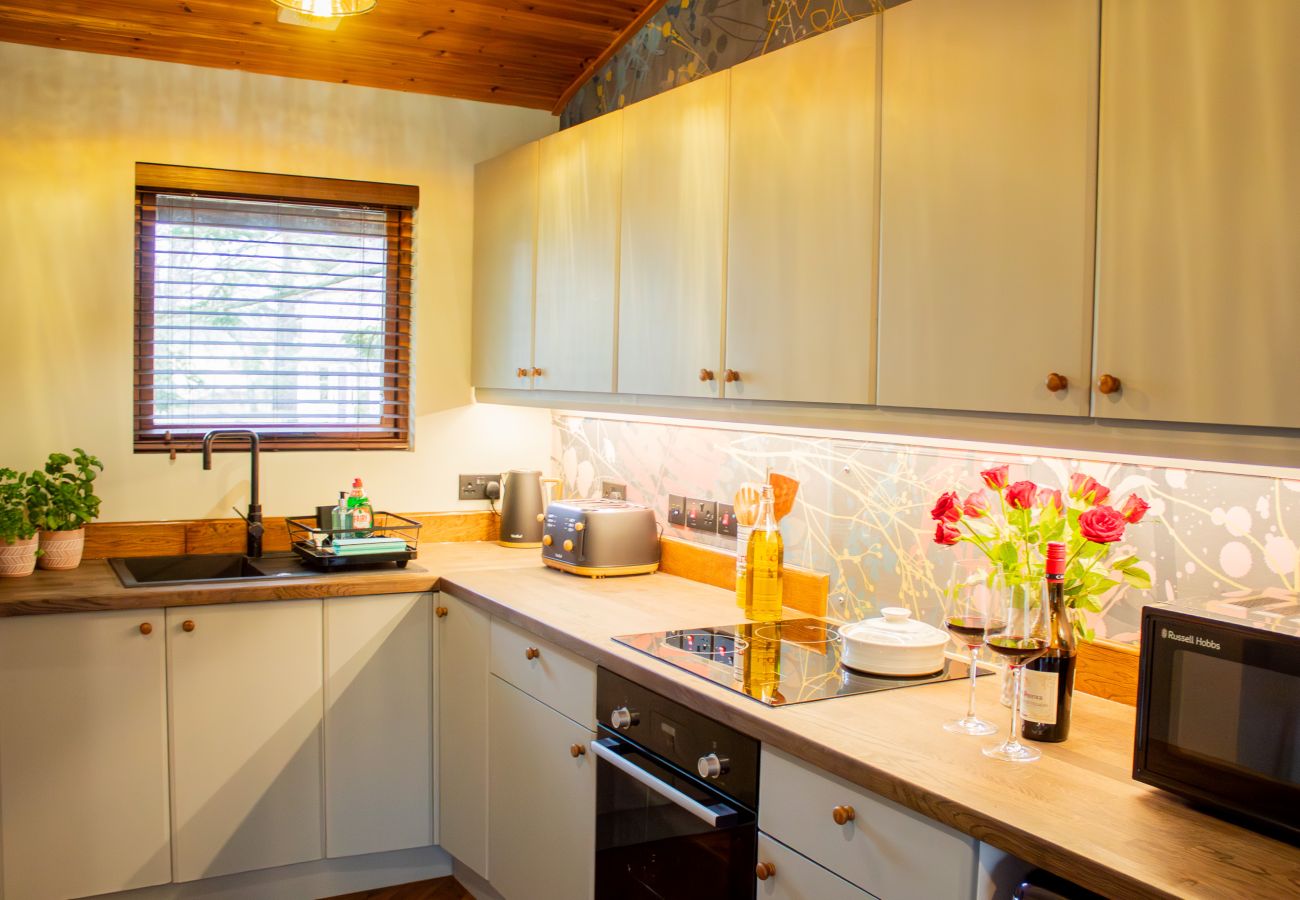 Fully equipped kitchen with oven microwave and sink. Styled with flowers and wine