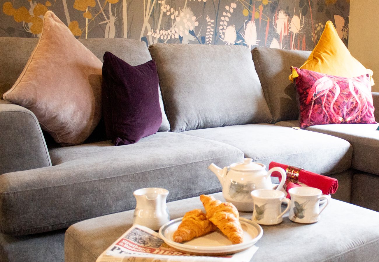 Breakfast tea and croissants  on the footstool by sofa