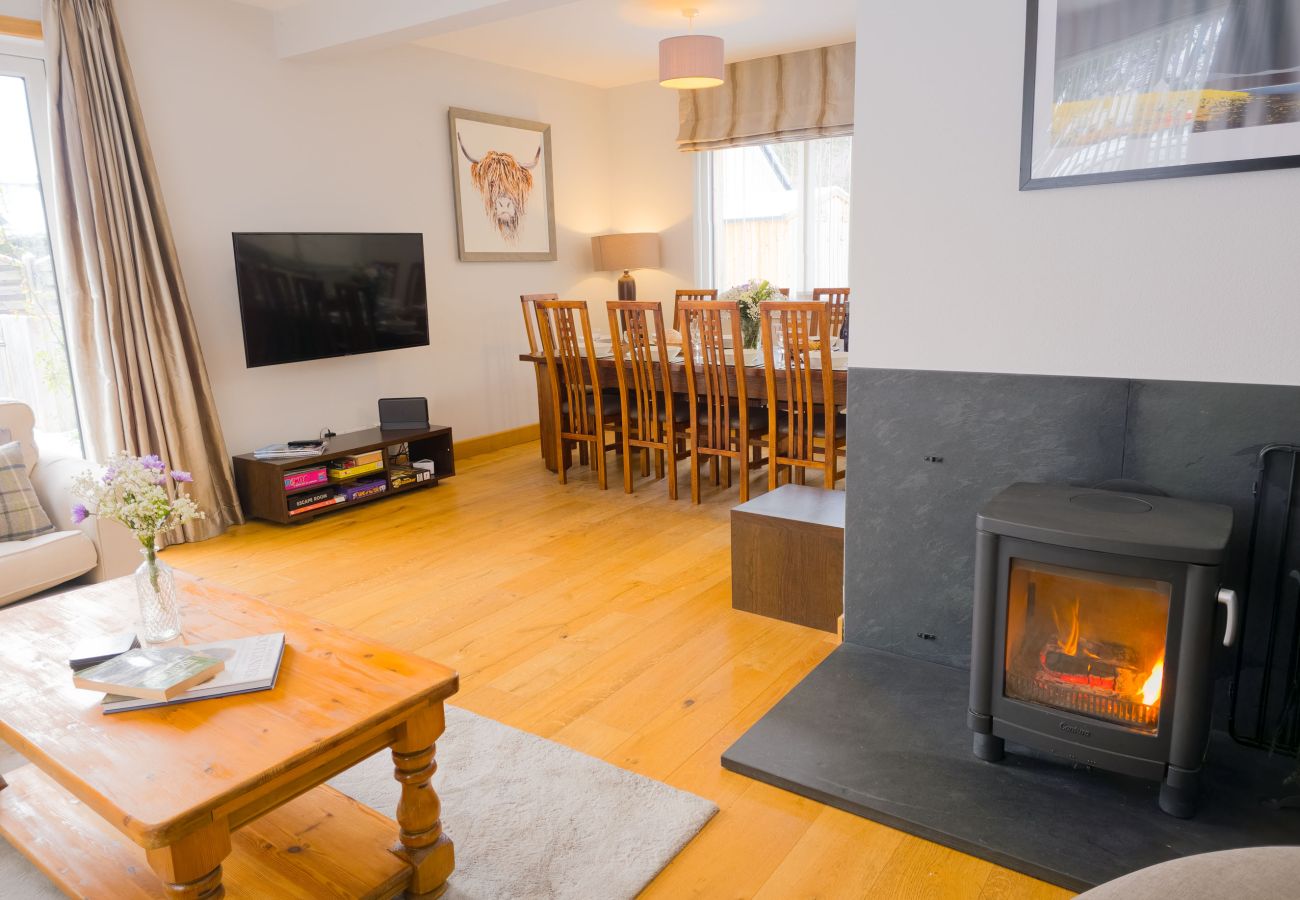 Bright open-plan lounge with log burner and seating