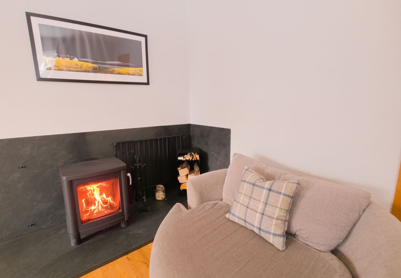 Comforable chiar beside log burner with magazines