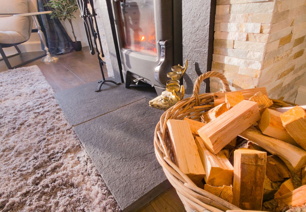 Crackling log fire in a stone fireplace ready for a cosy night.