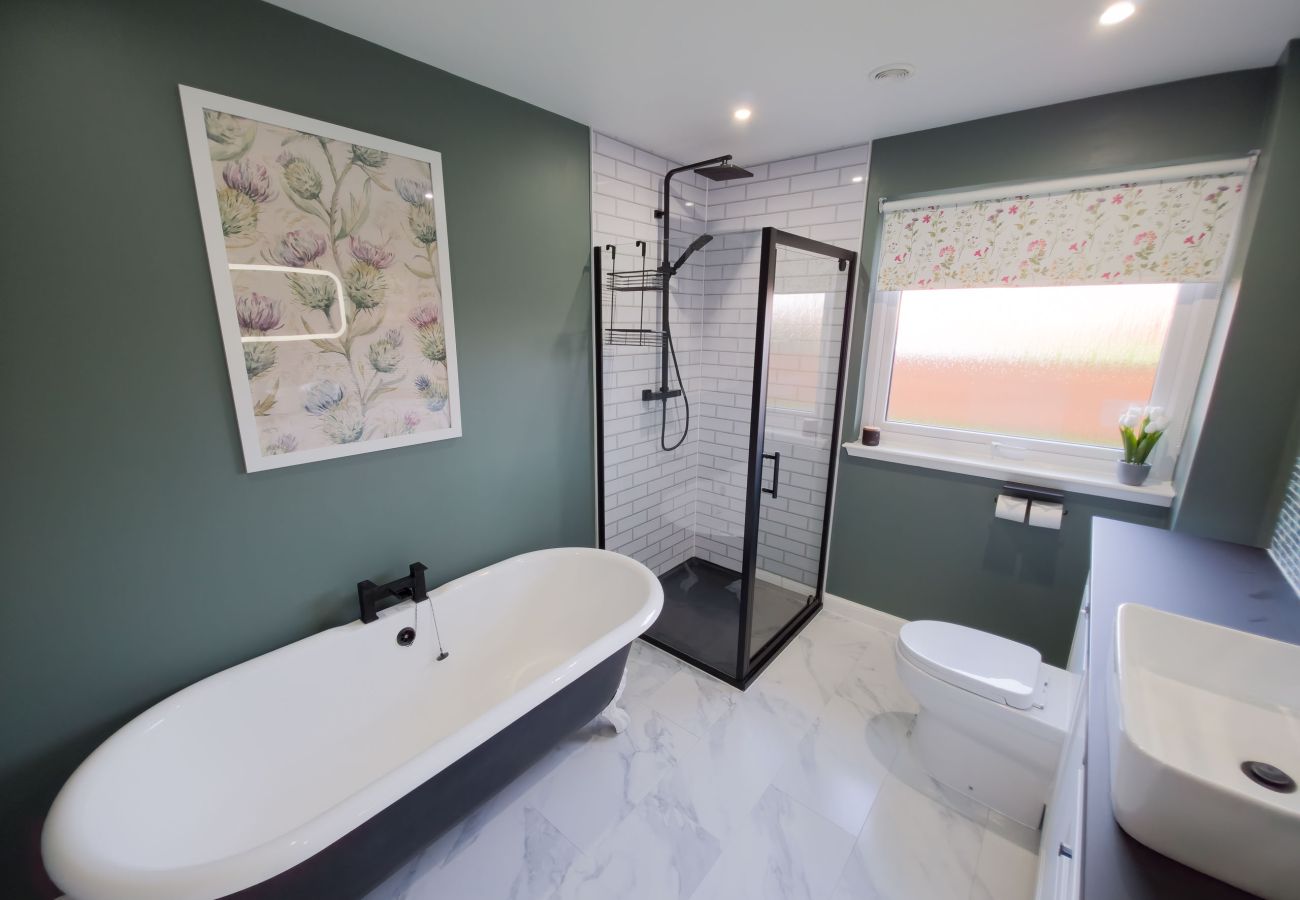 Modern bathroom with a deep freestanding bath and stylish decor.