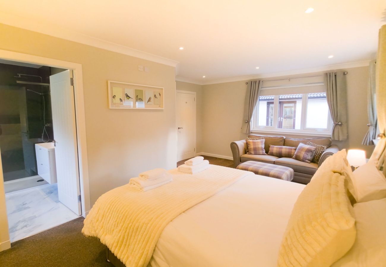 A stylish master bedroom with ensuite and cosy seating area