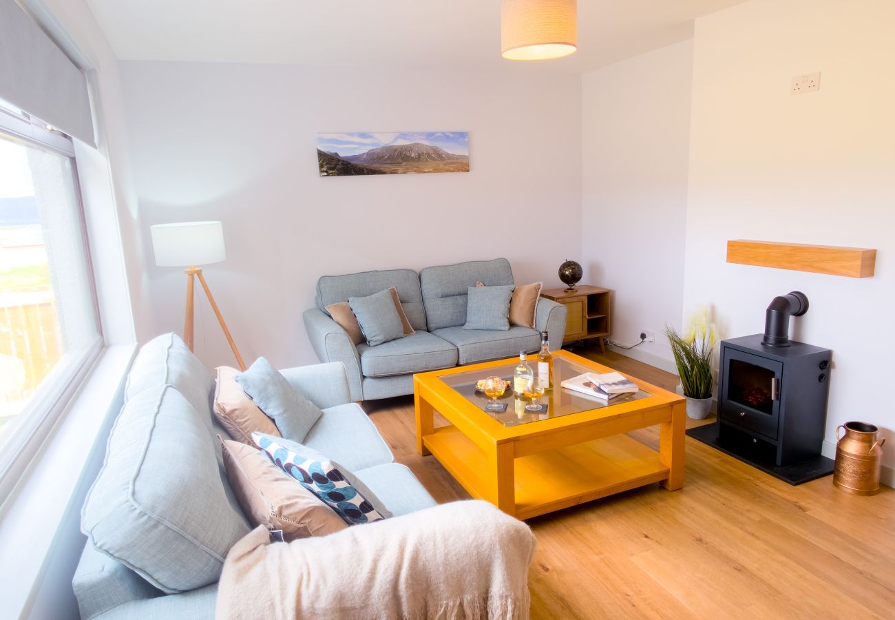 Bright living room with grey sofas and Highland landscape print at Lynemore Croft