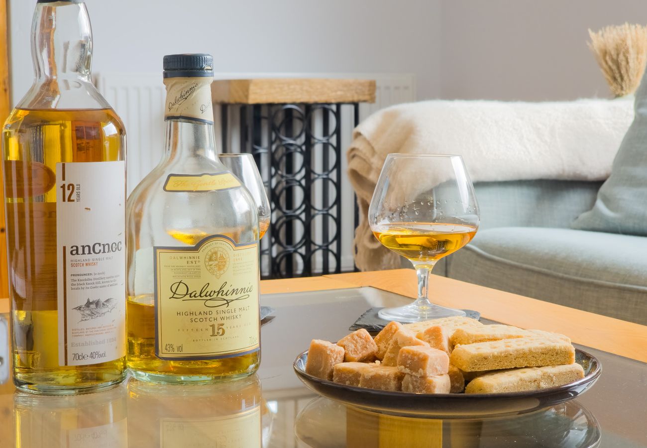 anCnoc and Dalwhinnie single malt whisky bottles with a poured dram and tablet at Lynemore Croft