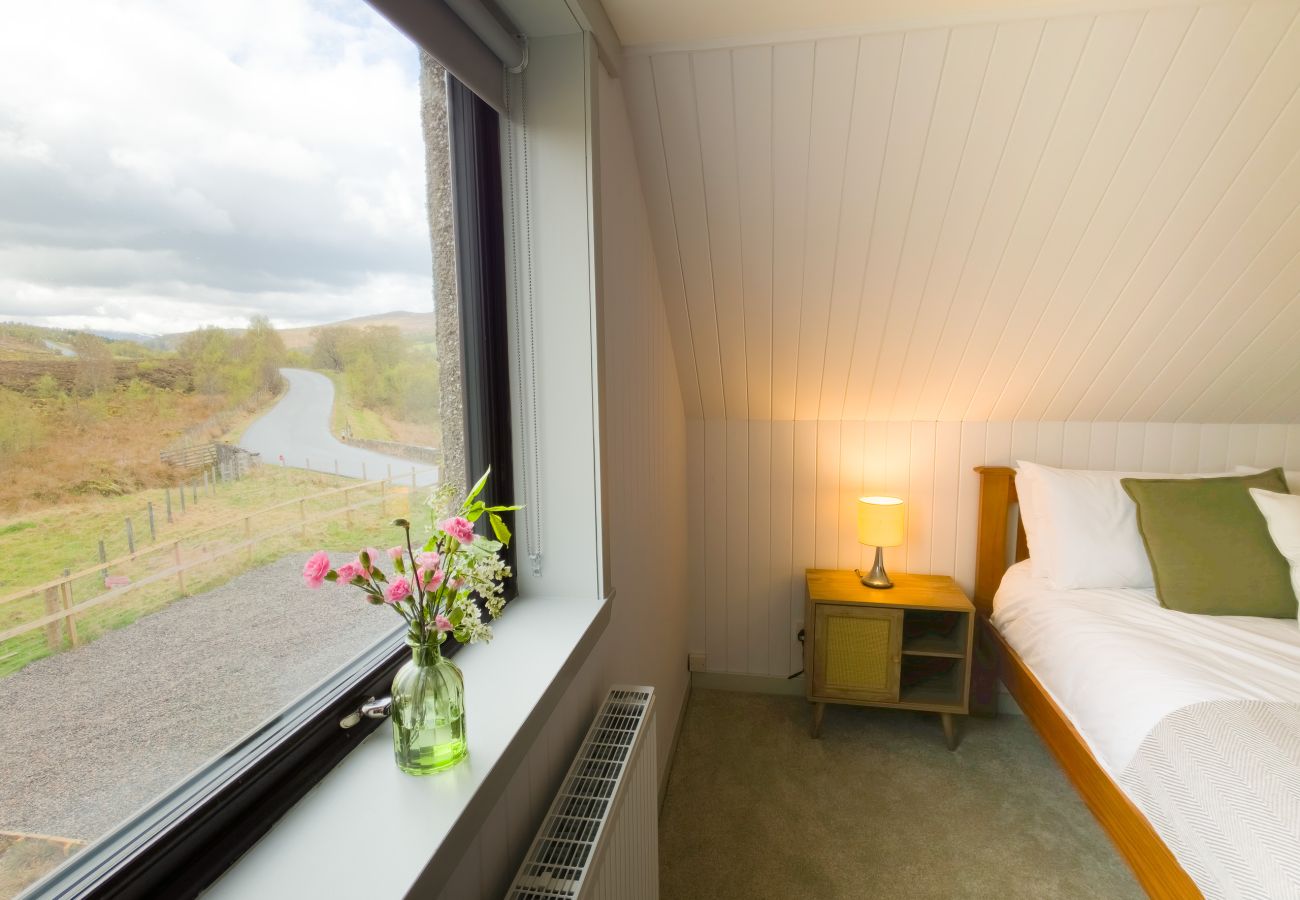 Bedroom window with panoramic Highland landscape view at Lynemore Croft