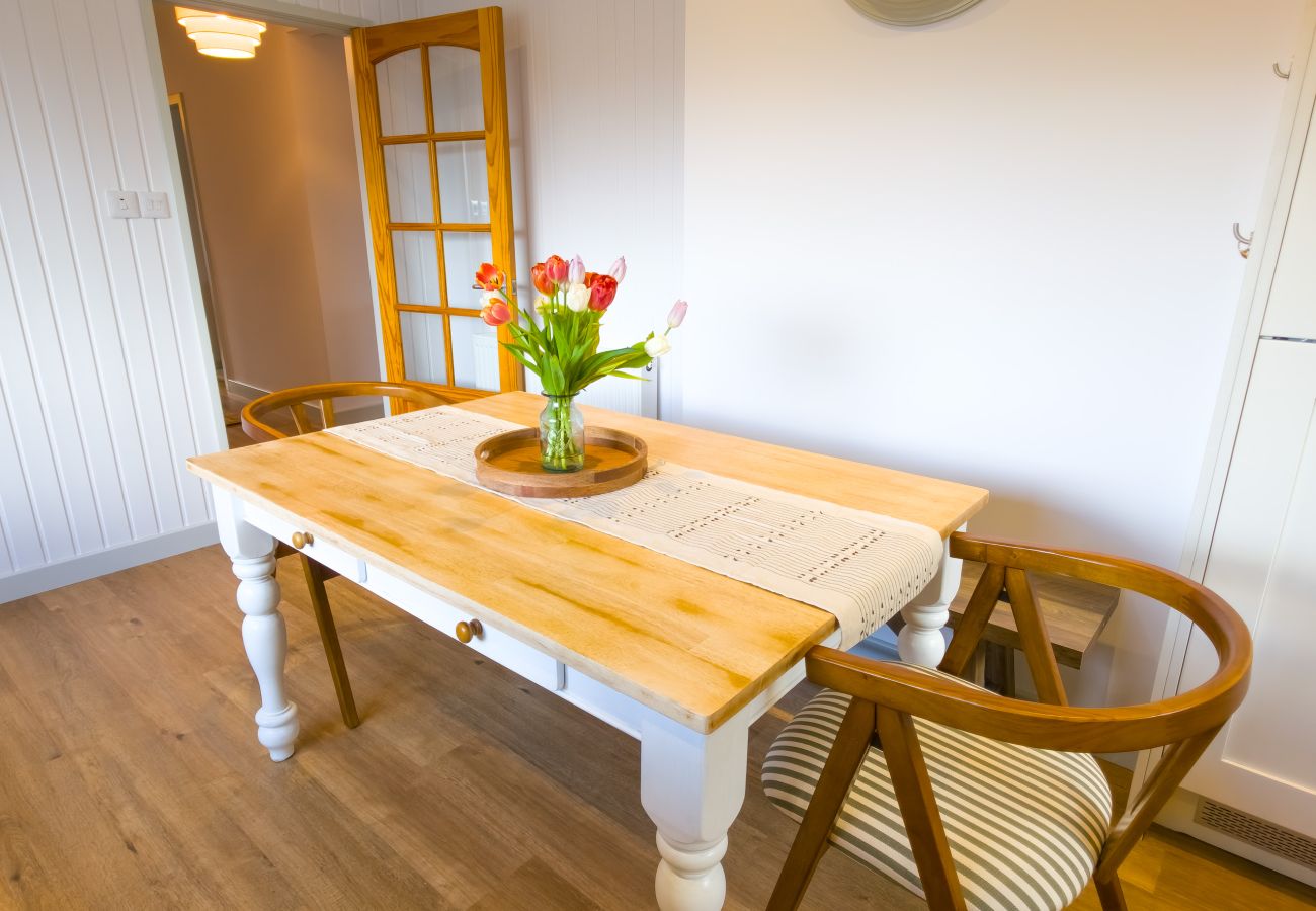 Farmhouse pine dining table with white painted legs at Lynemore Croft