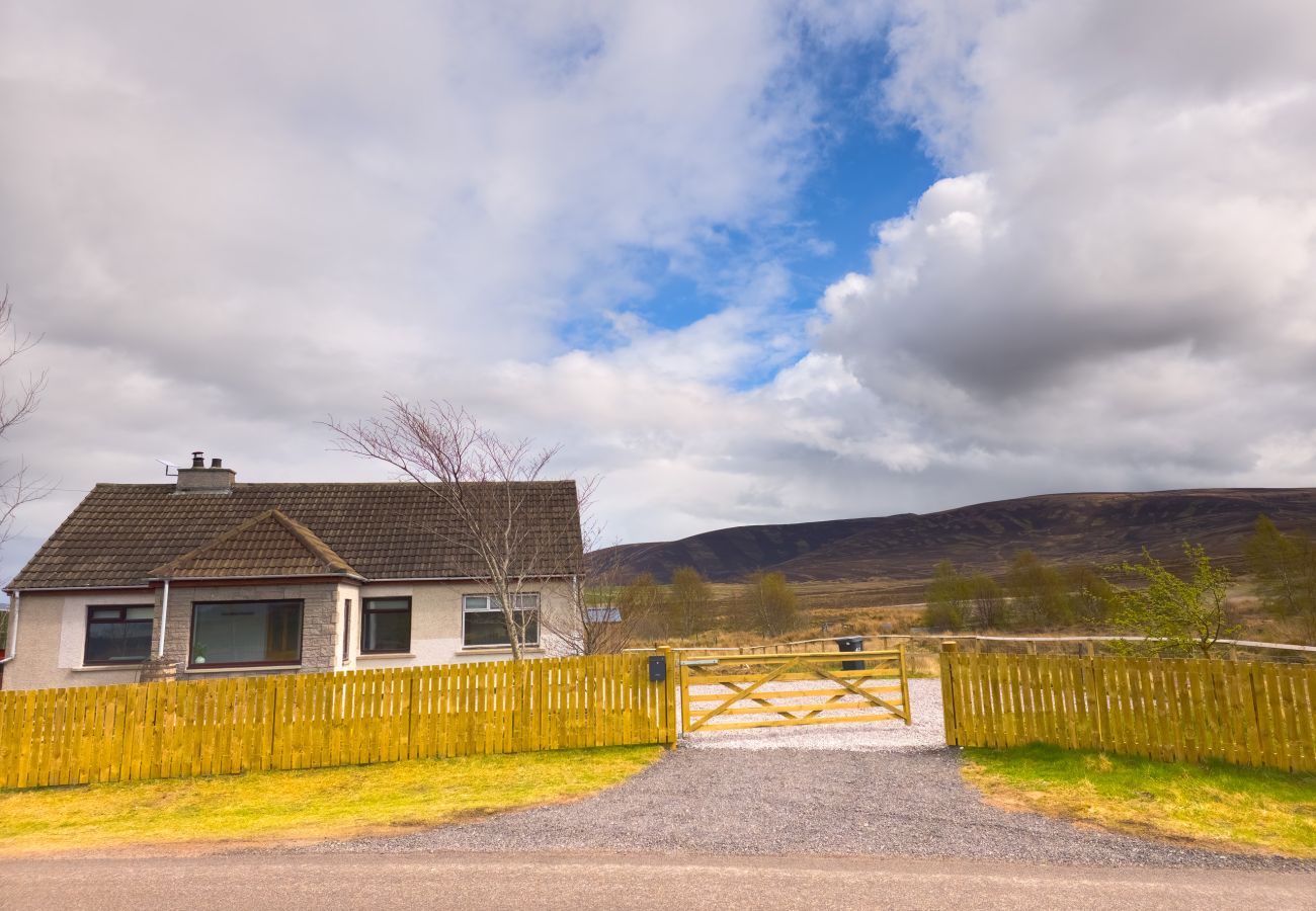 Lynemore Croft exterior with Highland hills backdrop and blue sky