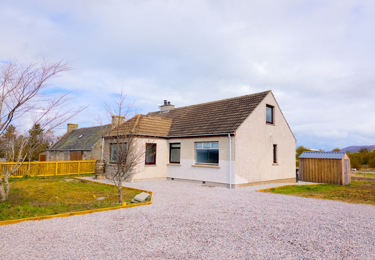 Lynemore Croft white holiday cottage exterior with private gravel driveway and Highland sky
