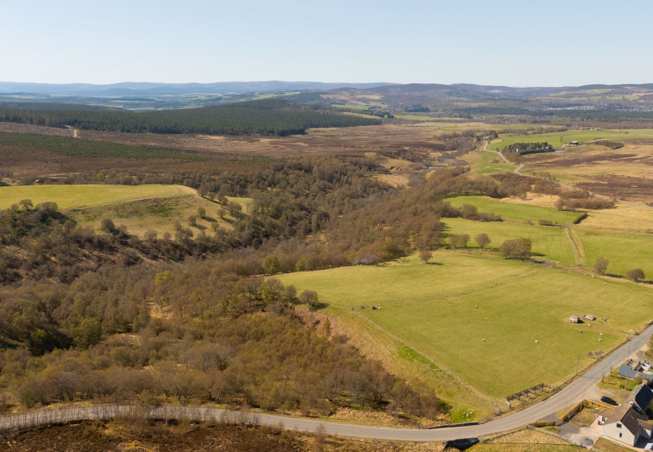 Aerial drone view of wooded glen and farmland on the scenic Grantown-on-Spey to Tomintoul road near Lynemore Croft