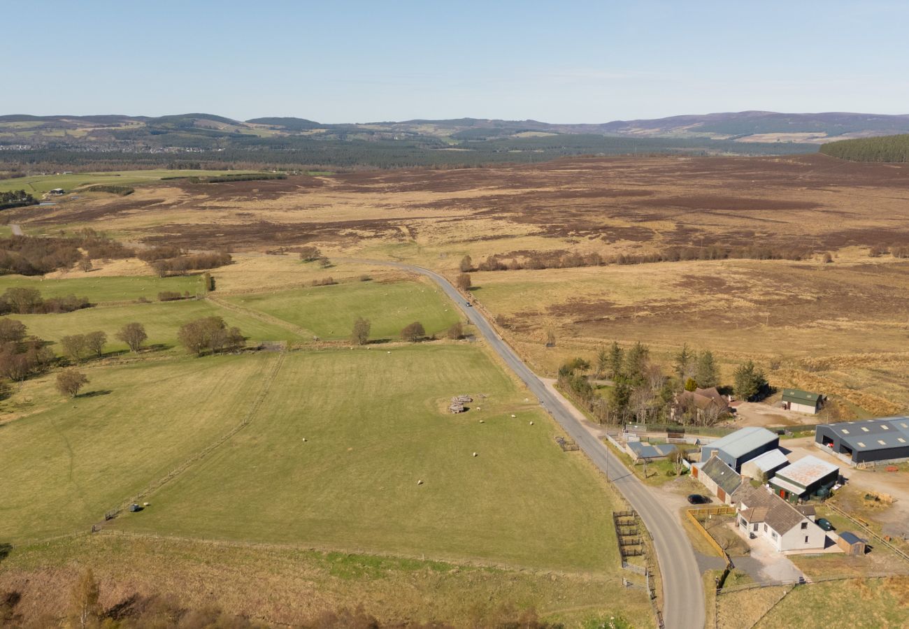 Aerial drone view of the scenic Grantown-on-Spey to Tomintoul road with Lynemore Croft and adjacent farm visible in the Highland landscape