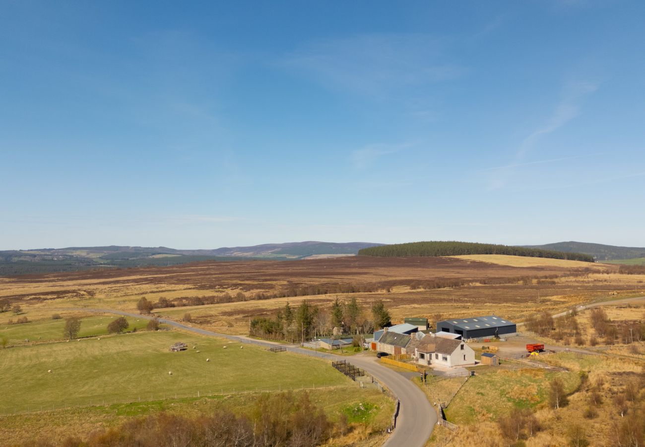 Drone aerial view of Lynemore Croft holiday cottage beside a working farm, surrounded by moorland on the Grantown-on-Spey to Tomintoul road
