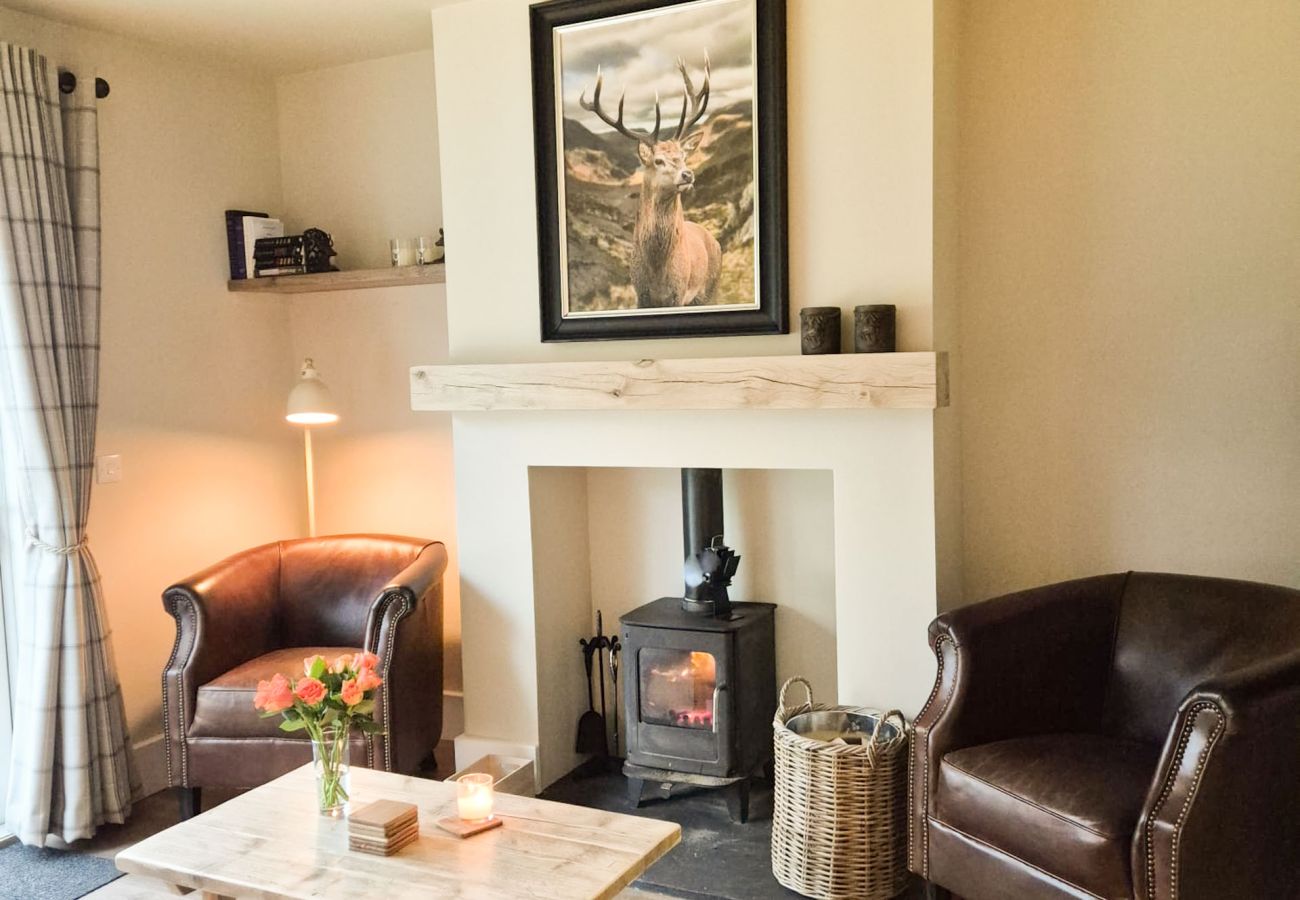 Living room at Betty's Highland Cottage with fireplace, log burner and leather sofas