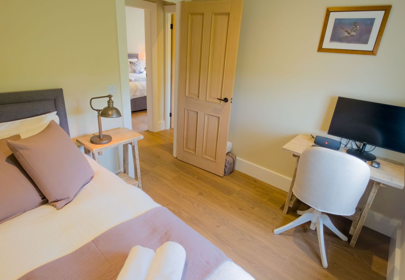 Twin bedroom with TV and pine doors at Betty's Cottage, Highland self-catering near Ruthven Barracks