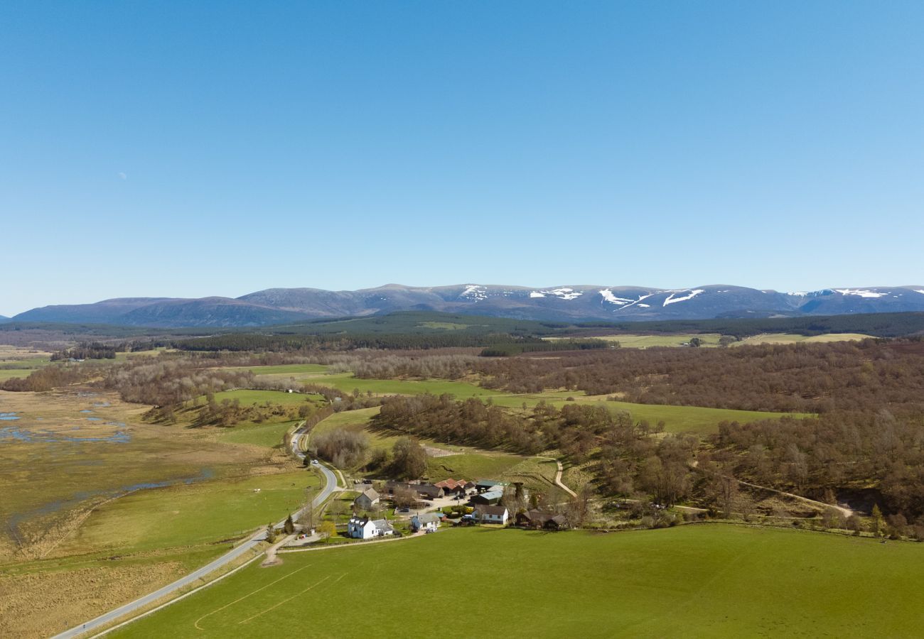 Aerial drone view of Betty's Cottage and Scottish Highland landscape with Cairngorm mountains