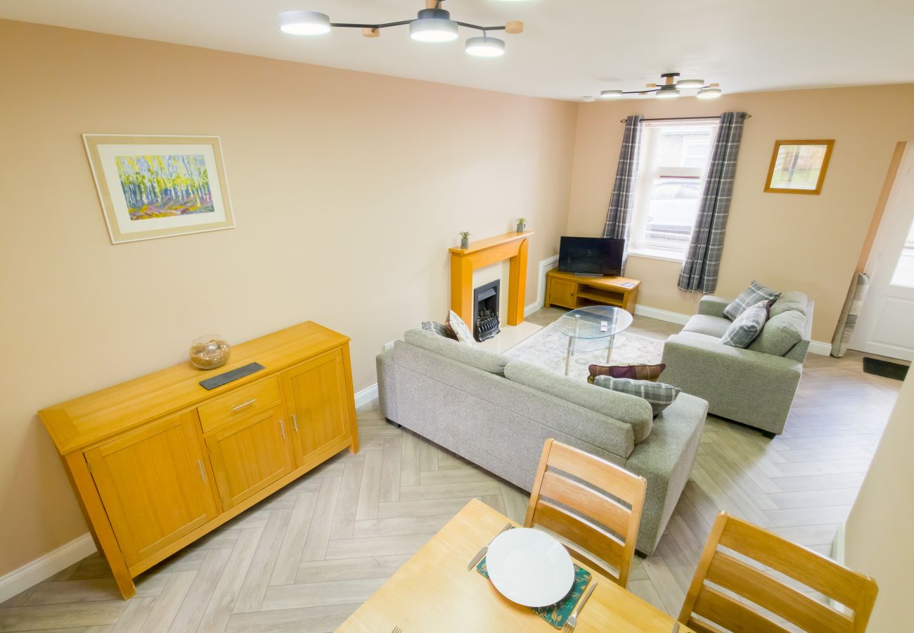 Living room with fireplace and herringbone floor at Inverness holiday rental