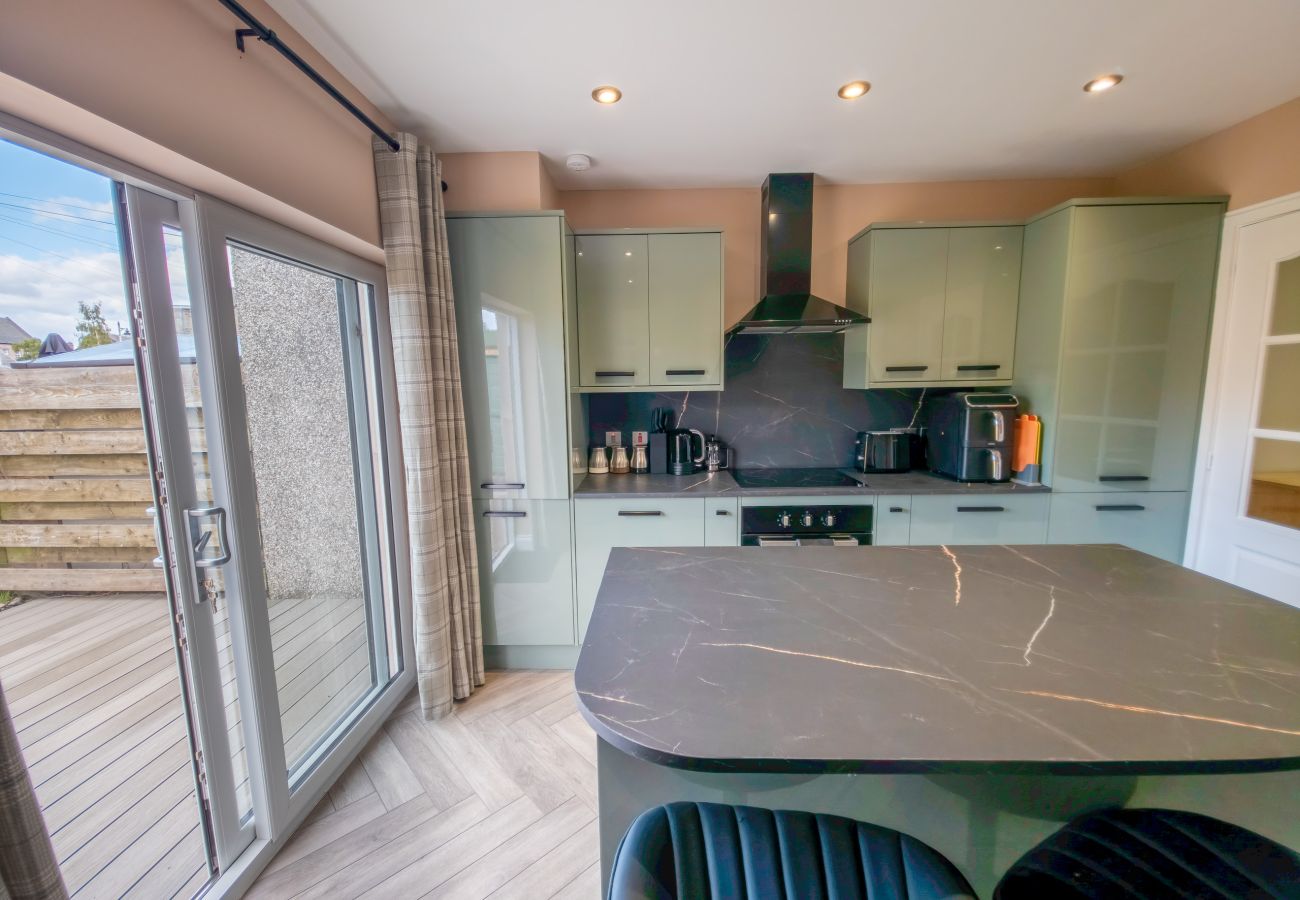 Bright open plan kitchen with large patio doors and herringbone floor