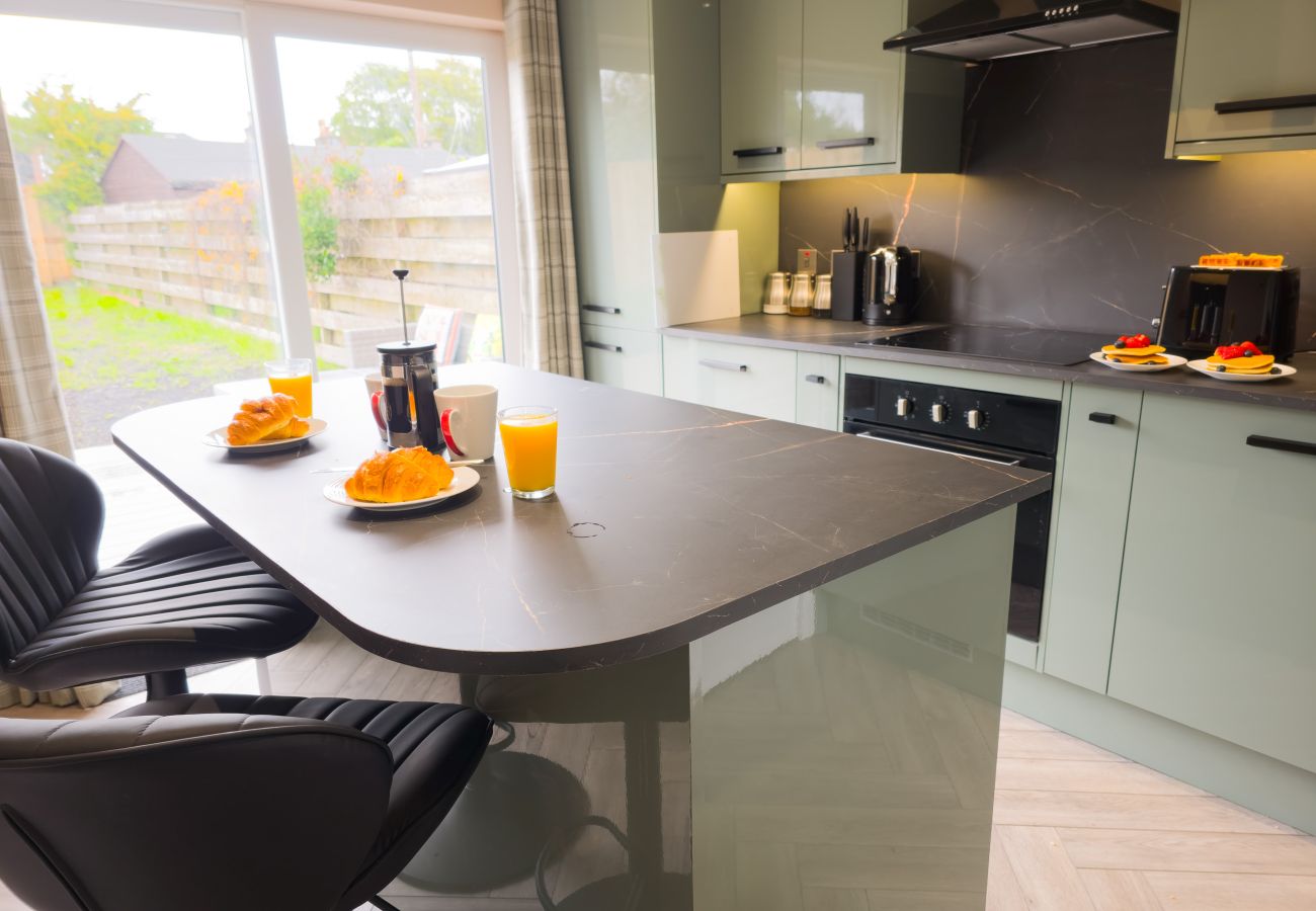 Open plan kitchen dining area with island and garden view at Inverness holiday rental
