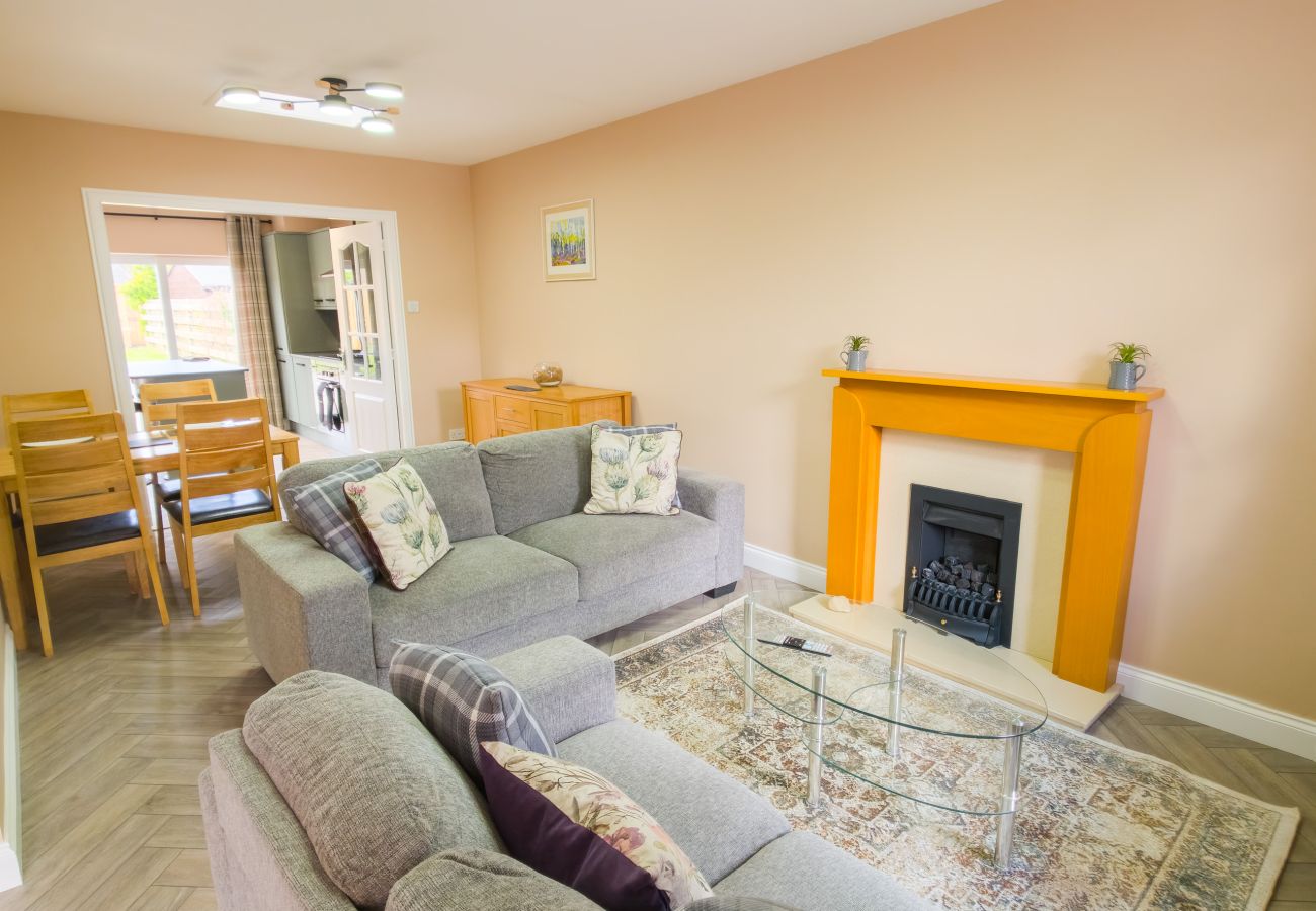 Bright living room with sofas and fireplace at 18 Hill Street Inverness holiday rental