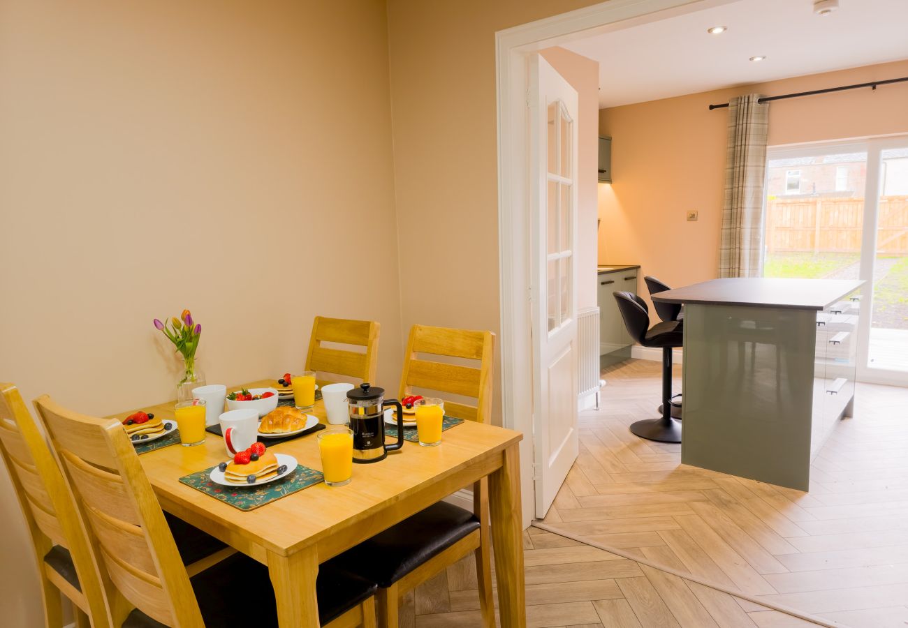 Dining room with wooden table and chairs at Inverness holiday flat