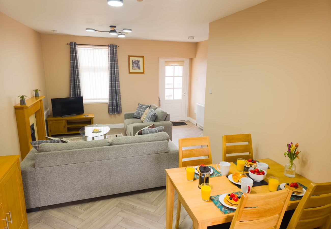 Open plan lounge with sofas and TV at Inverness Crown holiday let