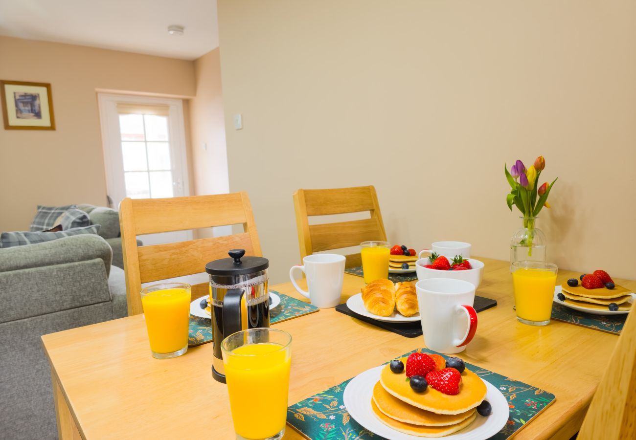 Dining table and chairs in open plan living space at Inverness holiday rental