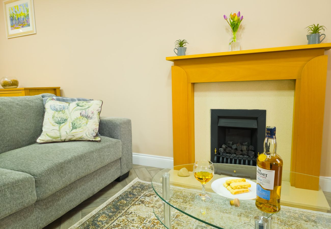 Inviting lounge with fireplace and sofa at Inverness Crown holiday let
