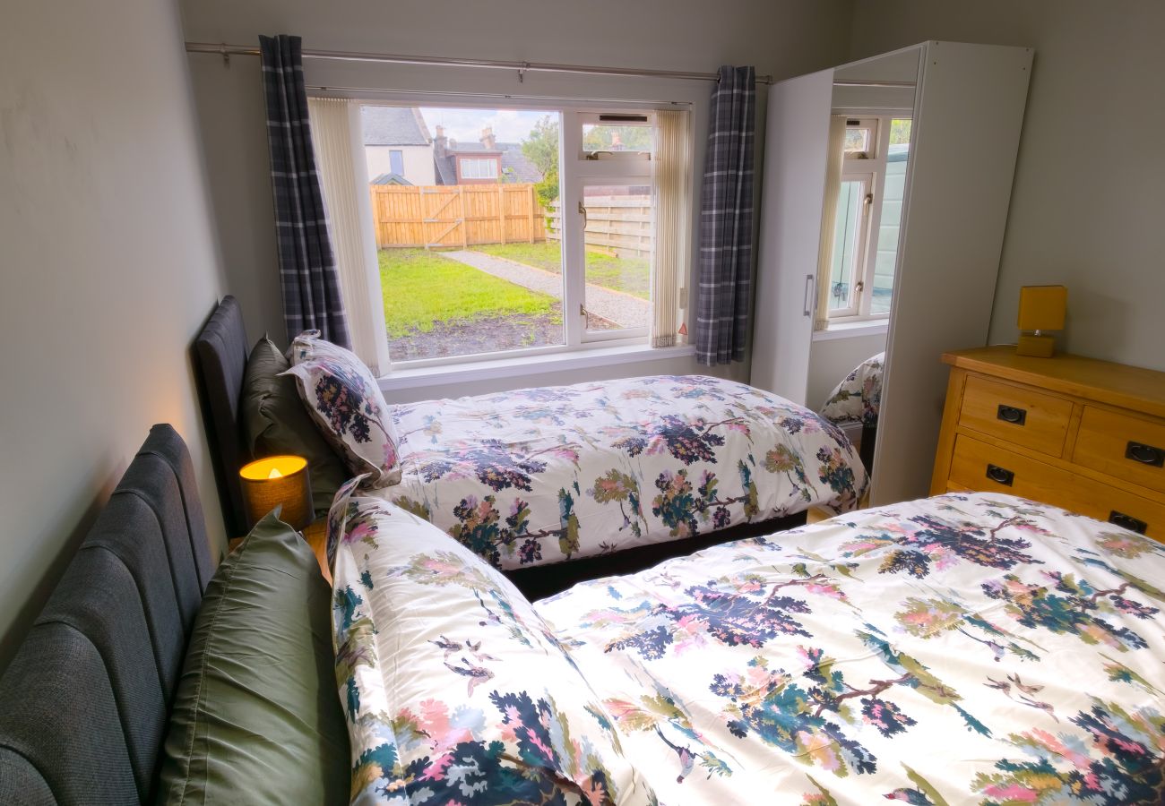 Twin bedroom with floral bedding and garden view at Inverness holiday rental