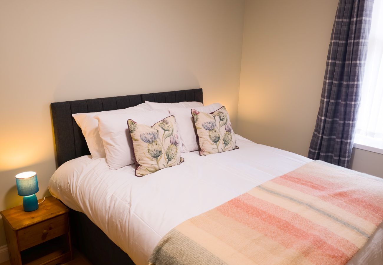 Stylish double bedroom with soft furnishings at Inverness Crown holiday let