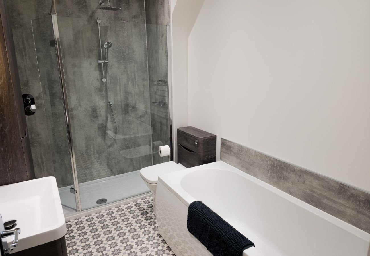 Modern bathroom with walk-in shower and bathtub at 18 Hill Street Inverness self-catering
