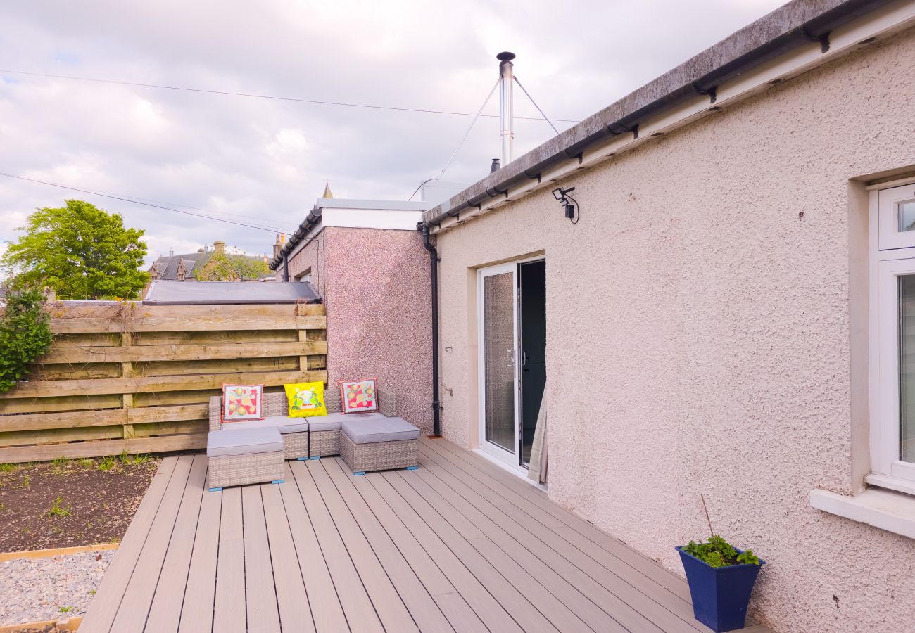 Decked garden terrace with outdoor seating at 18 Hill Street holiday cottage, Crown area Inverness